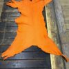 IMG_2016 Orange leather hide on a wooden surface.