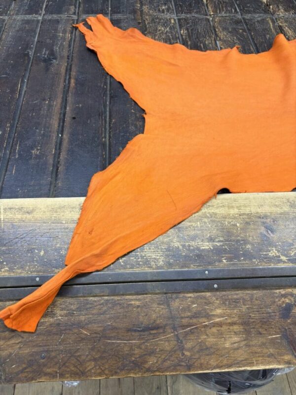 IMG_2017 Orange leather hide on wooden table.