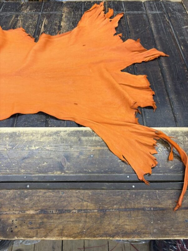 IMG_2018 Orange leather piece on wooden table.