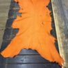 Orange leather hide on wooden table.