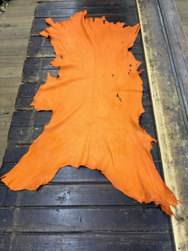 Orange leather hide on wooden table.