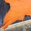 Orange leather hide on wooden surface.