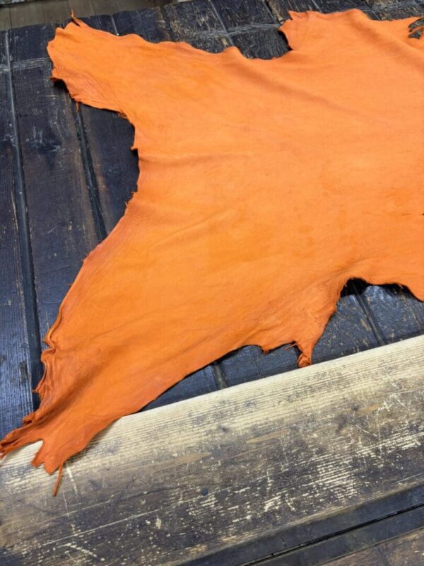 Orange leather hide on wooden surface.