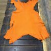 Orange leather hide on wooden surface.
