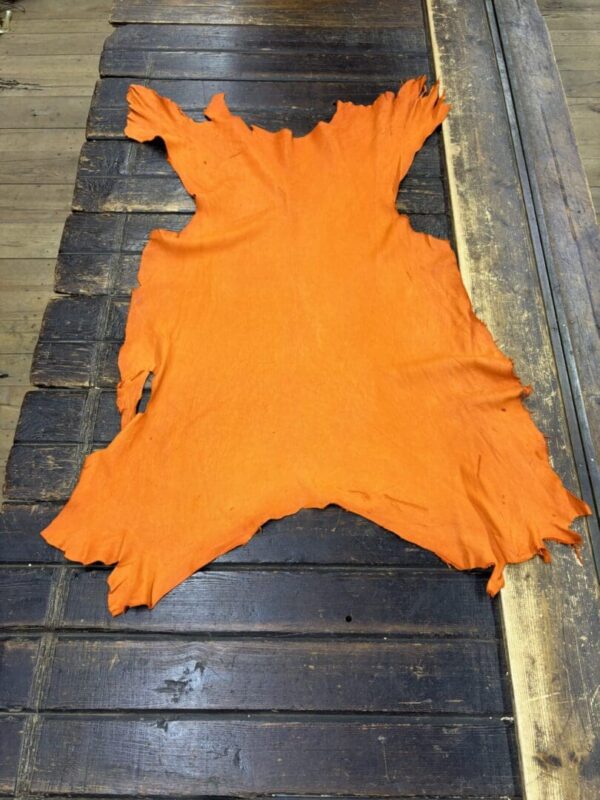 Orange animal hide on wooden surface.