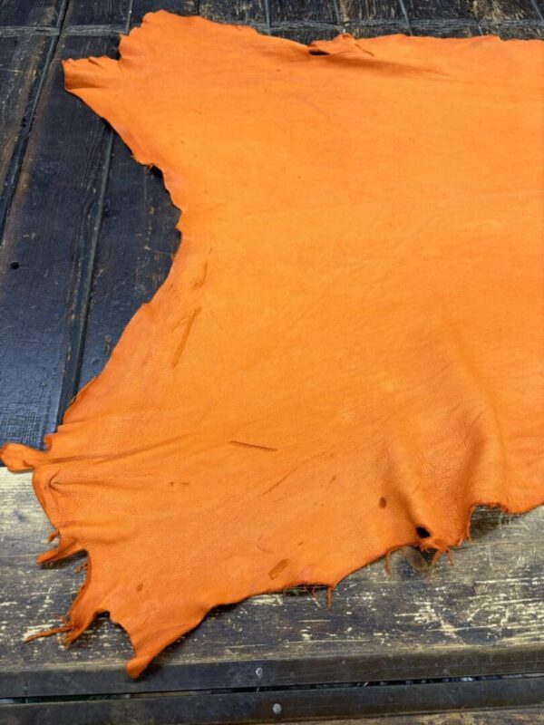 Orange leather hide on wooden surface.