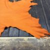 Orange leather hide on wooden table.