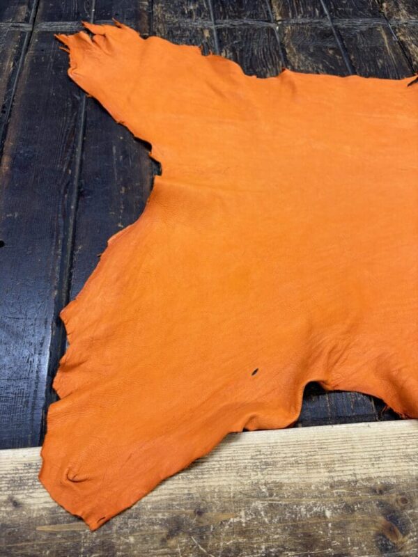 IMG_2033 Orange leather hide on wooden surface.