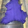 Purple leather piece on wooden surface.