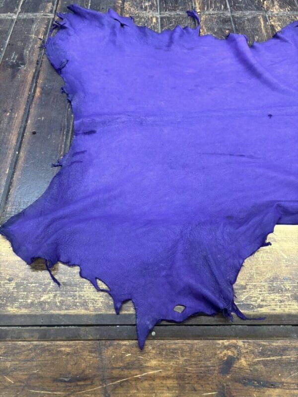 Purple leather hide on a wooden surface.