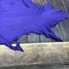 Purple leather hide on wooden surface.