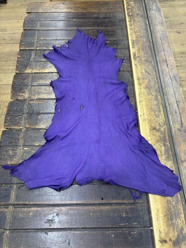 Purple leather piece on wooden surface.