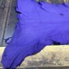 Purple leather hide on wooden surface.