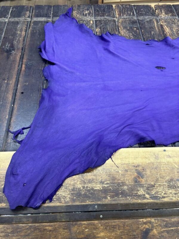 Purple leather hide on wooden surface.