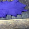 Purple fabric laid on a wooden surface.