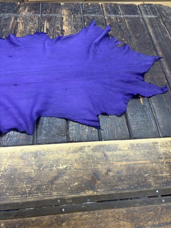 Purple fabric laid on a wooden surface.
