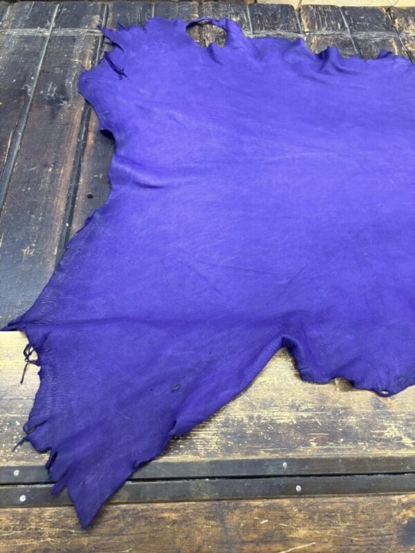 Purple leather piece on wooden surface.