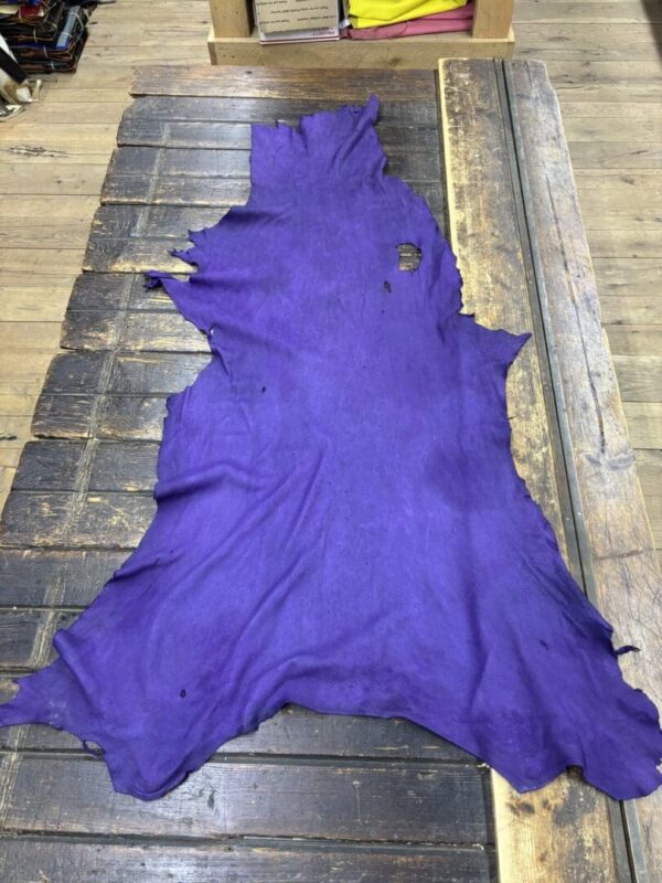 Purple leather hide on wooden surface.