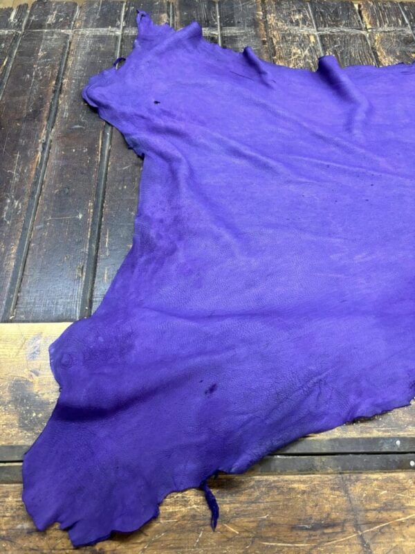 Purple leather lay on wooden surface.