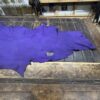 Purple leather piece on wooden table.