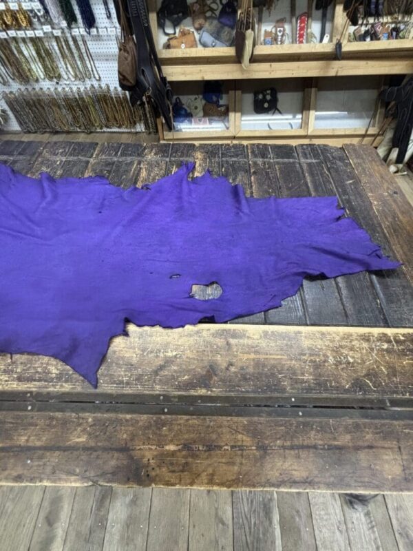 Purple leather piece on wooden table.