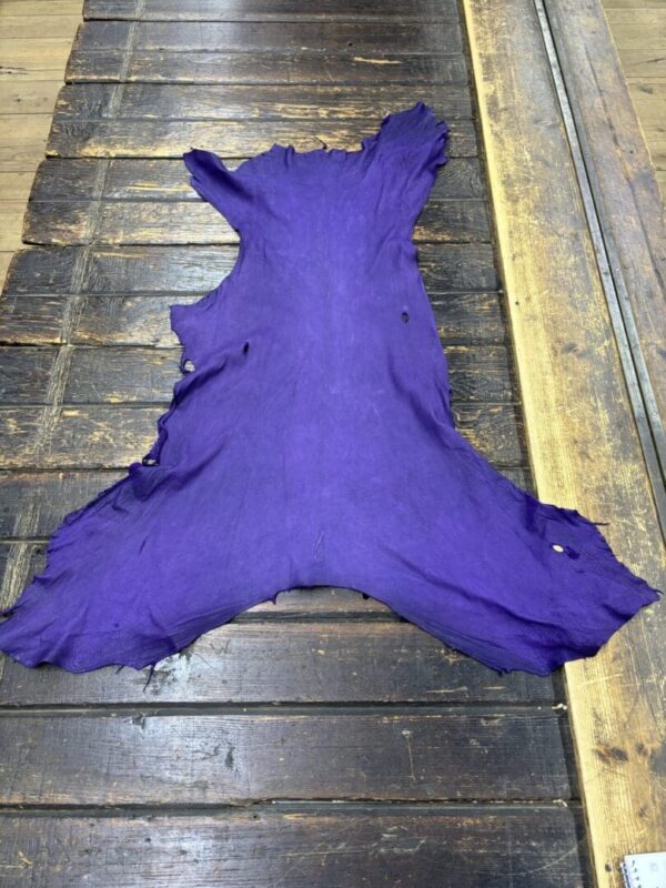 Purple leather hide on wooden surface.