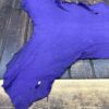 Purple leather hide on wooden surface.