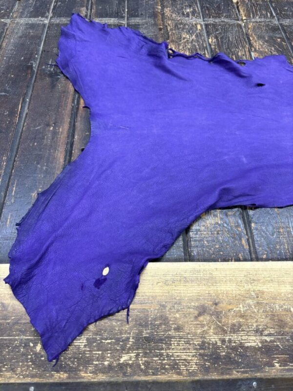 Purple leather hide on wooden surface.