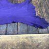 Purple leather piece on wooden surface.