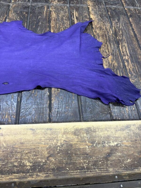 Purple leather piece on wooden surface.