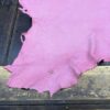 Pink piece of leather on wooden surface.