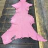 Pink leather hide on wooden table.