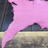 Torn pink fabric on wooden surface.