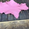 Pink leather piece on wooden surface.