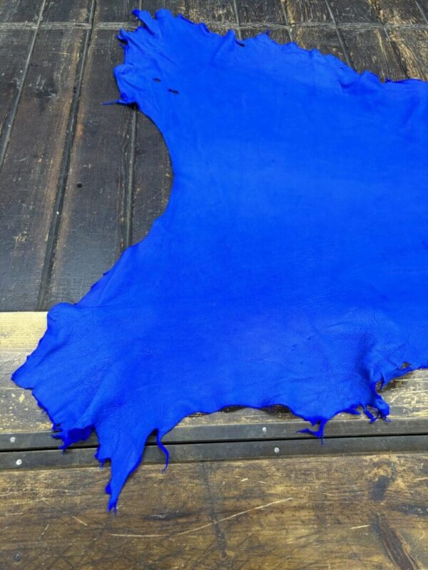 IMG_2081 Bright blue leather piece on wooden surface.
