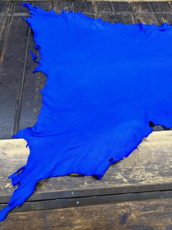 Bright blue leather hide on wooden surface.