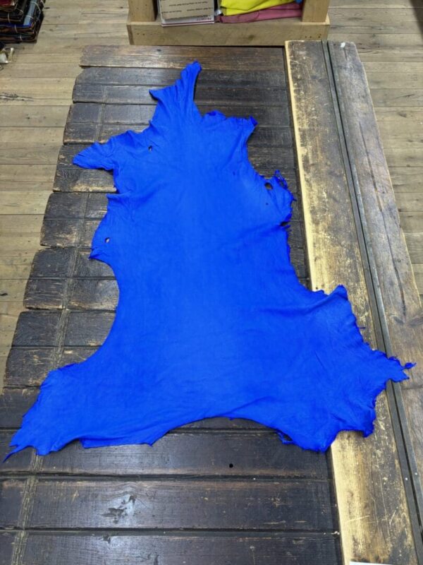 Bright blue leather hide on wooden surface.