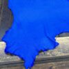 Bright blue leather hide on wooden surface.