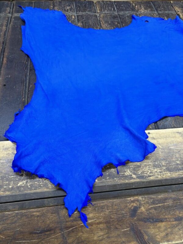 Bright blue leather hide on wooden surface.