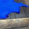 Bright blue leather piece on wooden surface.