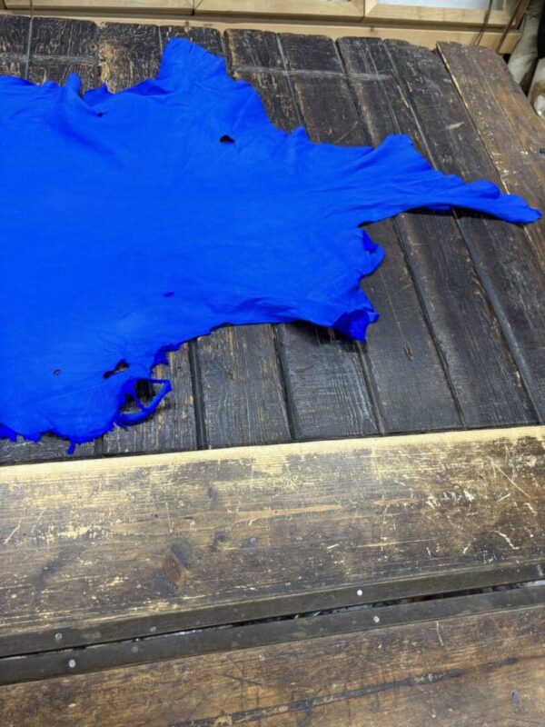 Bright blue leather piece on wooden surface.
