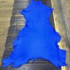 Bright blue leather hide on wooden surface.