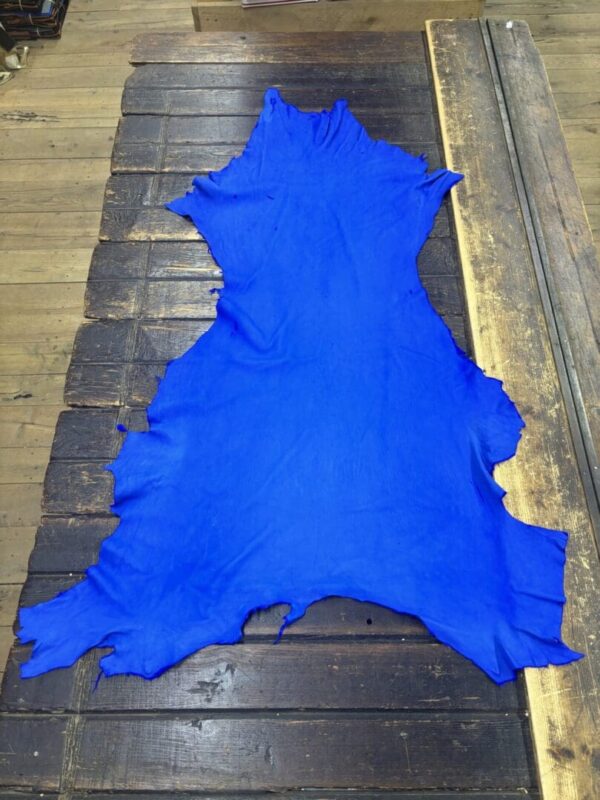 Bright blue leather hide on wooden surface.