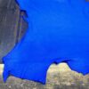 Bright blue leather hide on wooden surface.