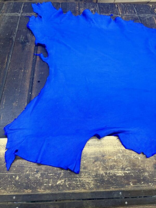 Bright blue leather hide on wooden surface.
