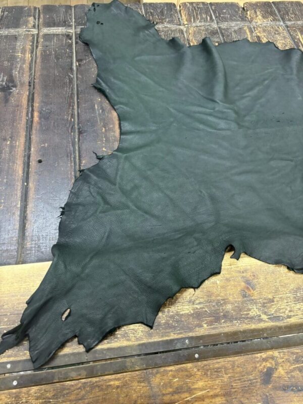 Black leather piece on wooden surface.