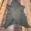 Green leather hide laid on wooden surface.