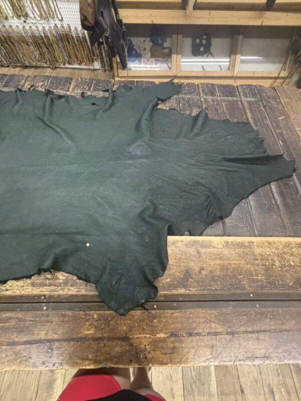Green leather hide on wooden table.