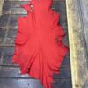 Red leather piece on wooden surface.