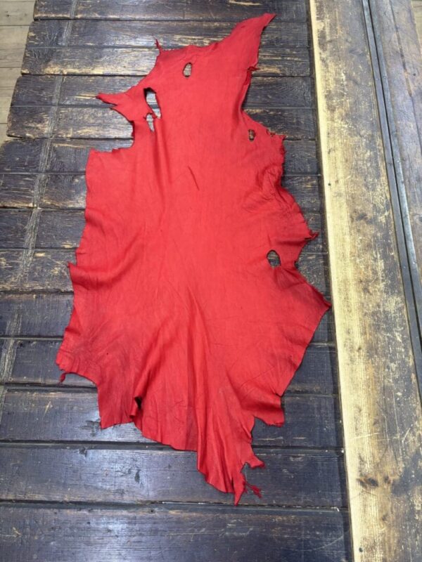 Red leather piece on wooden surface.